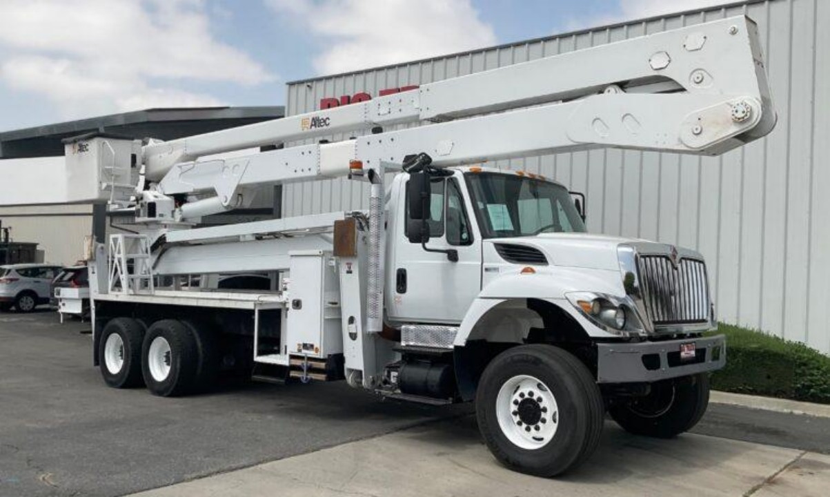 A bucket truck parked outside big truck equipment and sales