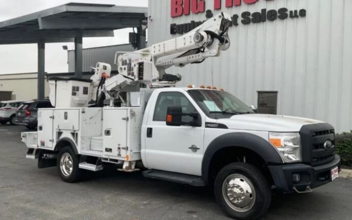 A white bucket truck with a crane extender